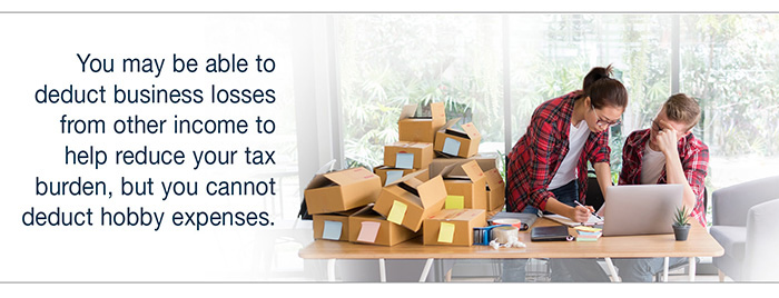 IMAGE of a couple doing an inventory on a laptop with shipping boxes next to them